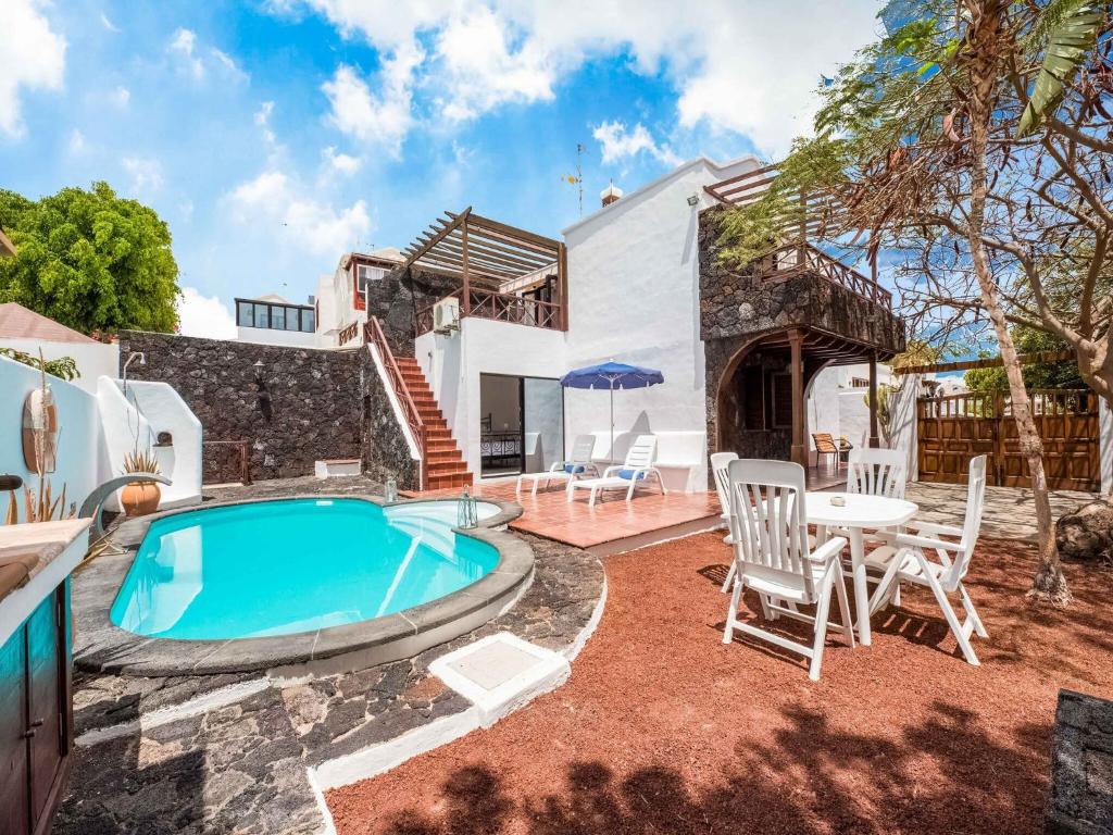 卡门港Belvilla by OYO Villa Aloe的别墅 - 带游泳池和桌椅