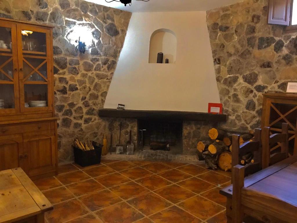Casas del CastañarCASA RURAL LA CABRERA的一间客厅,客厅内配有石头壁炉。