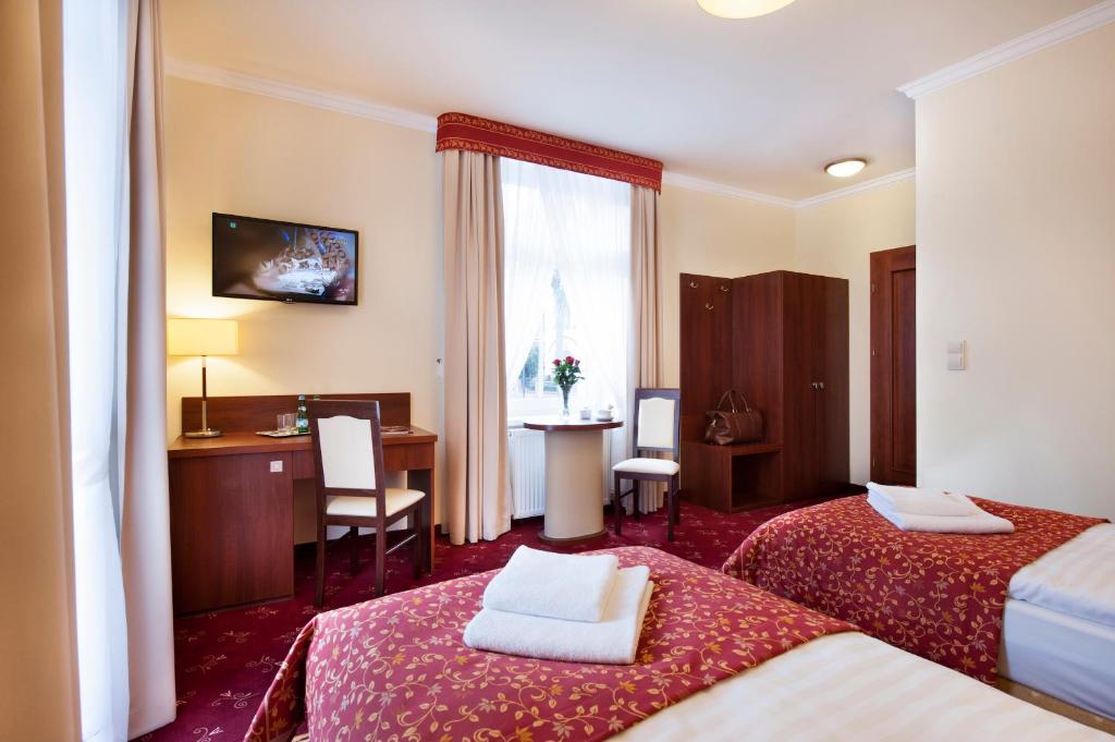 杜什尼基-兹德鲁伊Resort de Esperanto Sanatorium Uzdrowiskowe的酒店客房配有两张床和一张书桌