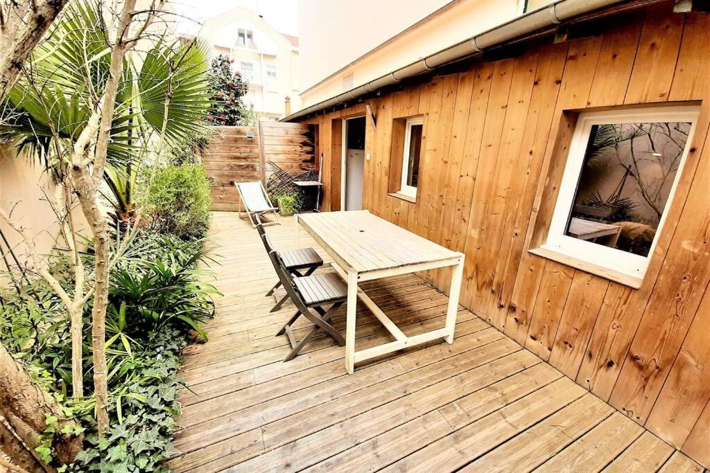 阿卡雄6 personnes, 2 studios indépendants avec terrasse.的木制甲板配有桌子和两把椅子