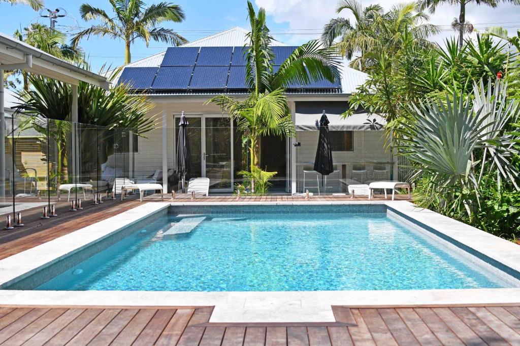 拜伦湾Byron Palms Guesthouse & Spa - Adults Only的一座房子后院的游泳池