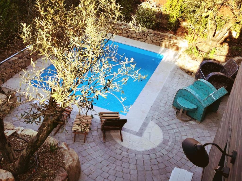 圣布里文莱丝皮恩Cottages du Valcoquet的游泳池旁设有椅子和一棵树