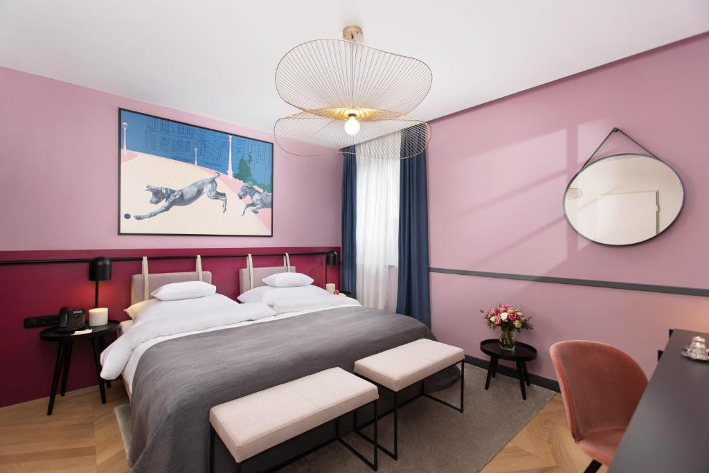 布达佩斯Alice Hotel的卧室配有一张带粉红色墙壁的大床