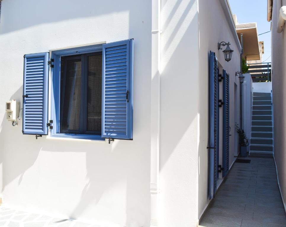 帕拉代西翁Casa terrazzo的白色的建筑,设有蓝色百叶窗和楼梯
