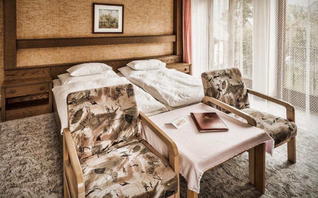毛特恩多夫schaus Lüftenegger Ferienhaus的一间卧室配有一张床、一把椅子和一本书