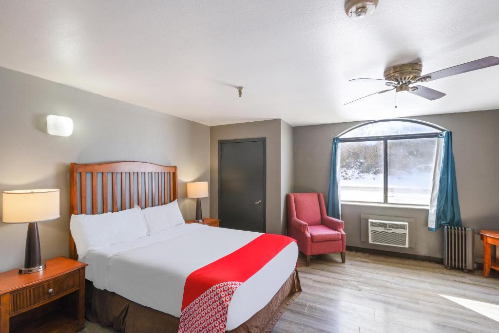 爱德蒙OYO Hotel Edmond - University of Central Oklahoma的卧室配有床、椅子和窗户。