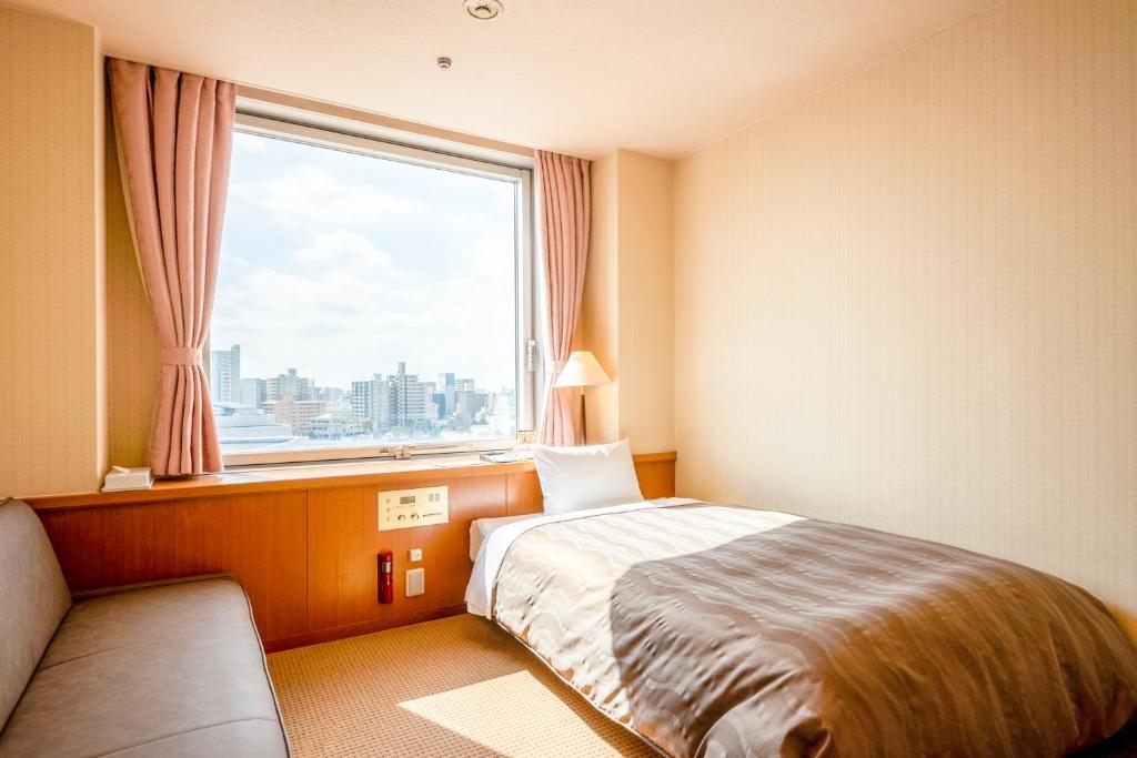 广岛广岛市本卡高丽会馆的酒店客房设有一张床和一个大窗户