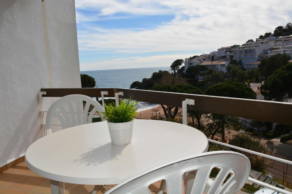 滨海托萨Apartamento Cala Salionç 12 primera linea de playa Tossa de Mar的阳台上配有白色的桌椅,享有海景