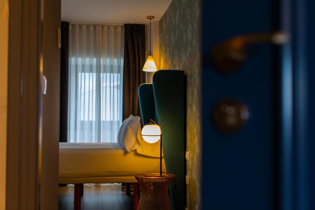 里瓦德奥HOTEL JAVIER MONTERO的一间卧室配有床、灯和窗户