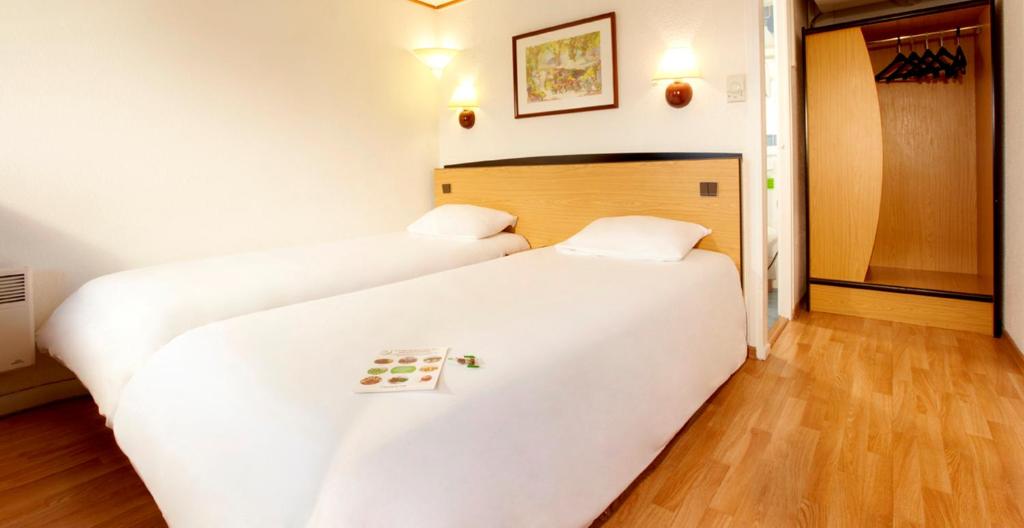 莫伯日钟楼毛贝奇酒店的配有白色床单的客房内的两张床