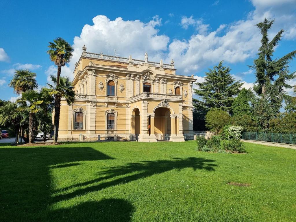 布雷西亚Villa San Giuseppe的一座种有棕榈树的大黄房子