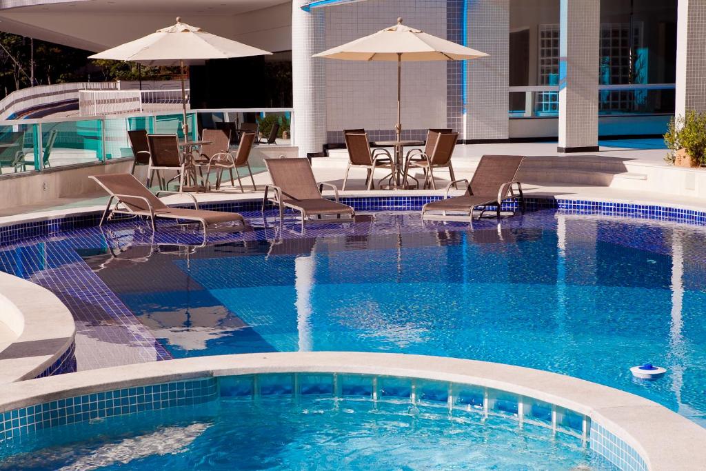 尤西德福拉总理公园酒店的一个带椅子和遮阳伞的大型游泳池