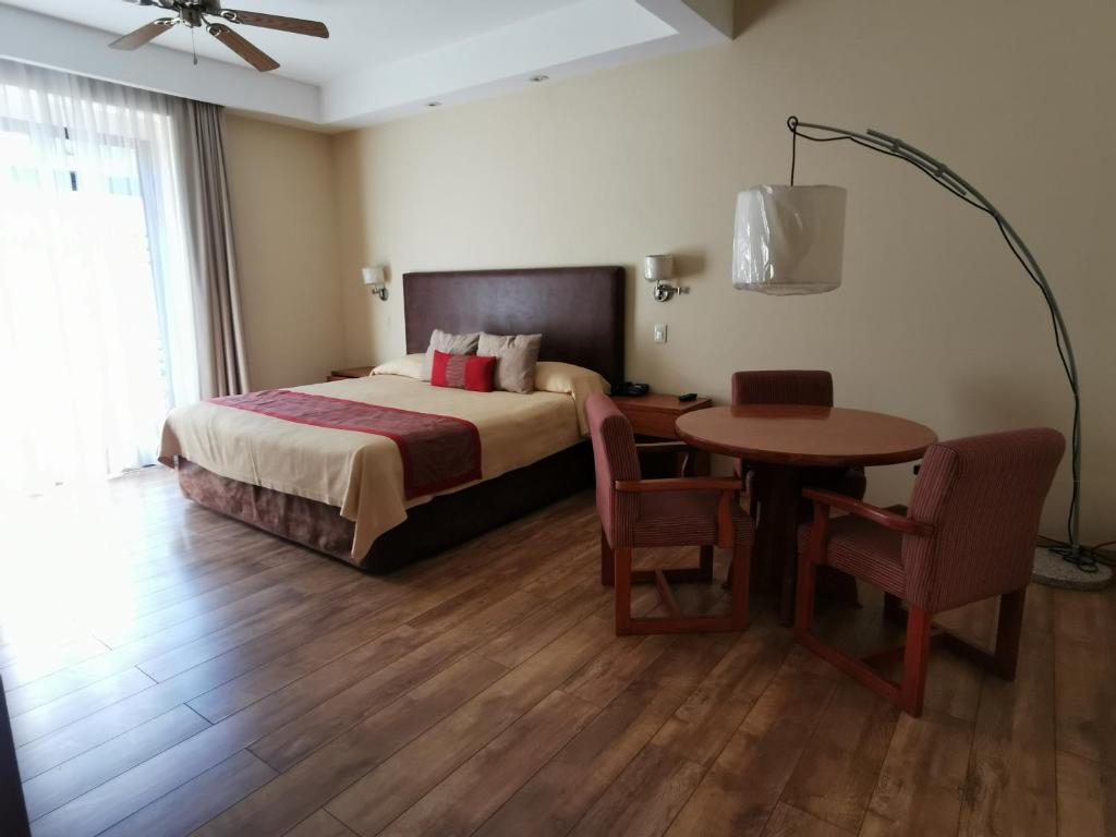 墨西哥城吉洛酒店的酒店客房带一张床、一张桌子和椅子