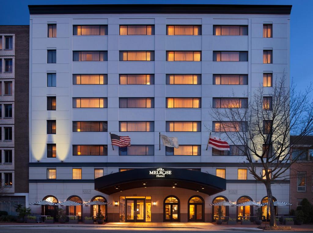 华盛顿Melrose Georgetown Hotel的一座悬挂美国国旗的酒店大楼