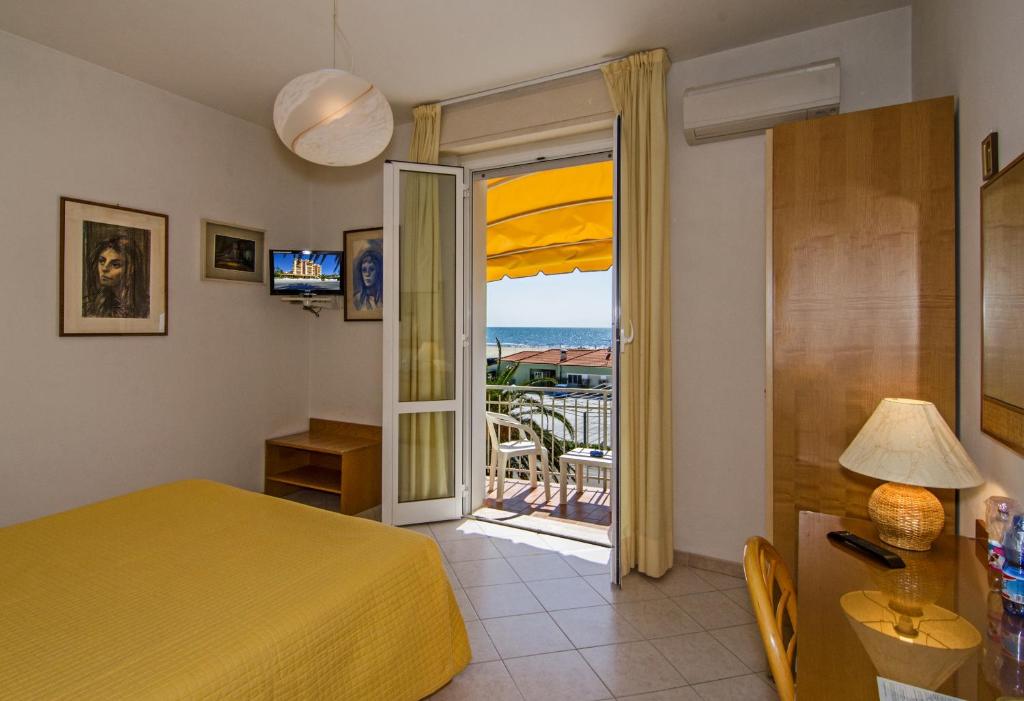 马里纳-迪-皮特拉桑塔阿尔克酒店的一间卧室设有一张床,并有通往阳台的门