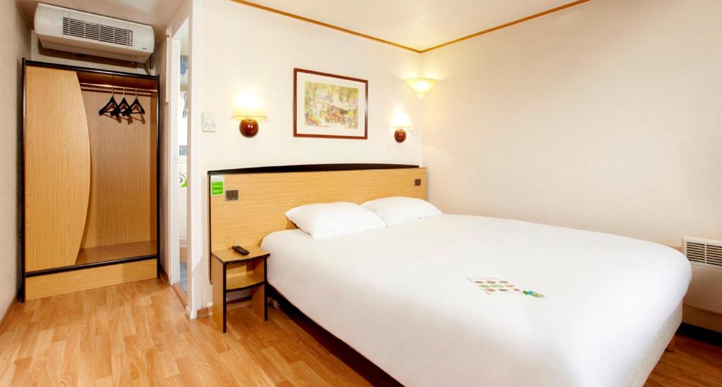 盖斯波尔塞姆钟楼斯塔伯格伊吉奇杰斯坡谢姆酒店的卧室配有一张白色大床