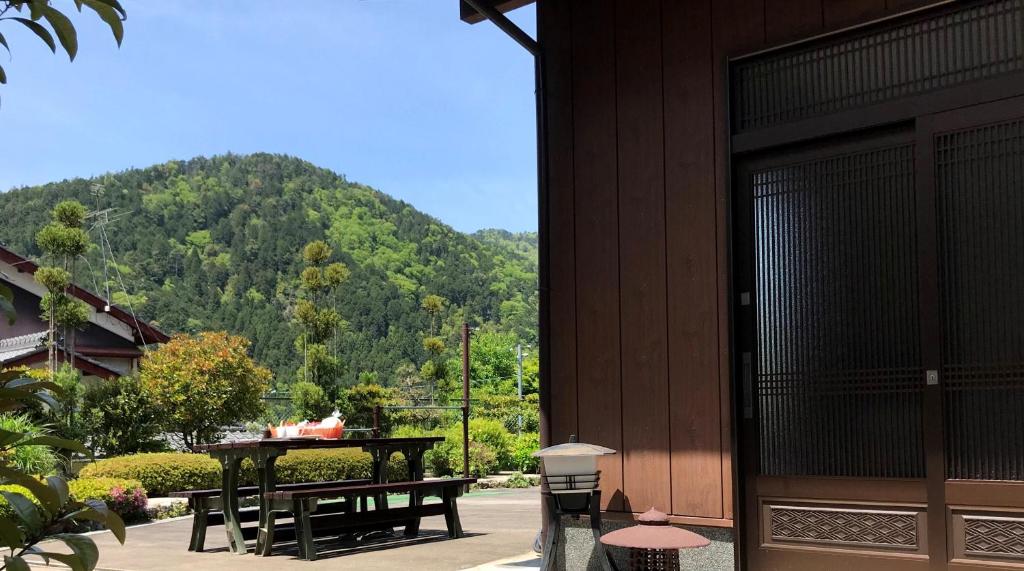 京都Ohara Sensui Surrounded by Beautiful Nature的一个带桌子和长椅的庭院和山地