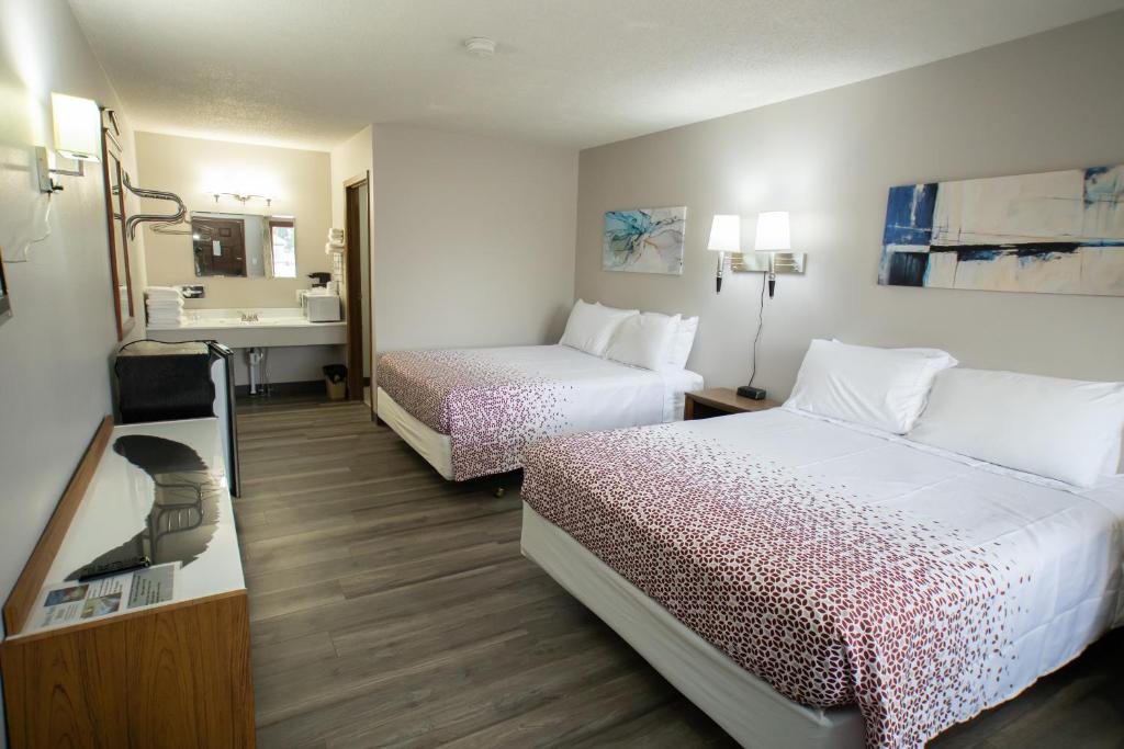 ArapahoeShady Rest Motel的酒店客房设有两张床和盥洗盆