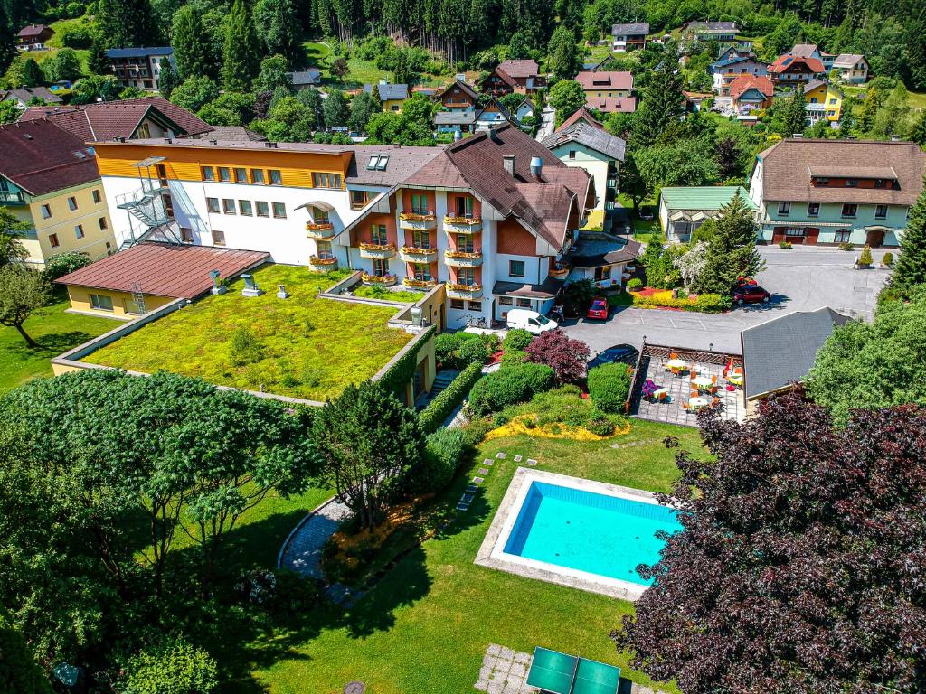 滨湖费尔德Hotel Burgstallerhof的享有带游泳池的房屋的空中景致