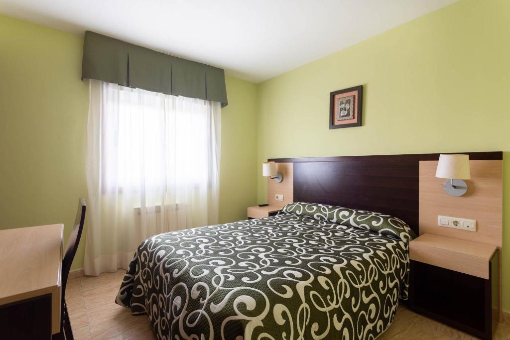 O Mesón Do Vento Hotel Canaima的一间卧室配有一张床、一张书桌和一个窗户。