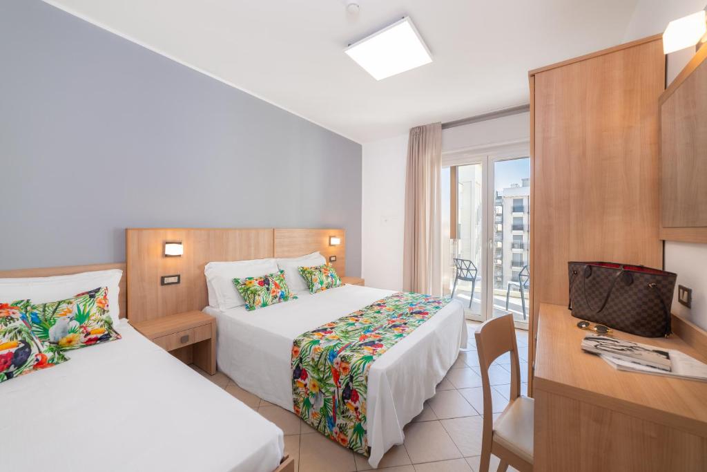 里乔内Hotel Amalfi - Smart Hotel的酒店客房配有两张床和一张书桌
