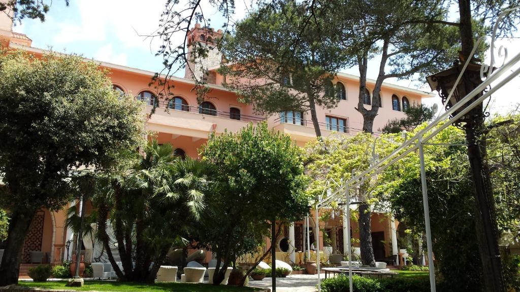 马丁纳弗兰卡圣米歇尔公园酒店的一座橘色的建筑,前面有树木