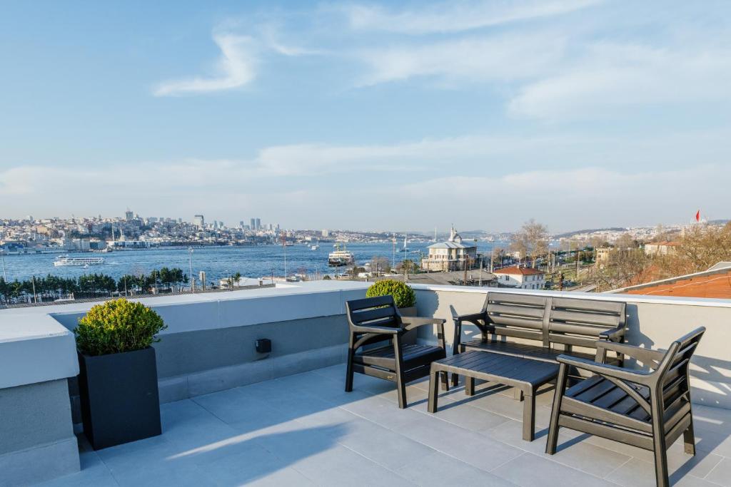 伊斯坦布尔梦幻博斯普鲁斯酒店的阳台配有椅子,享有水景
