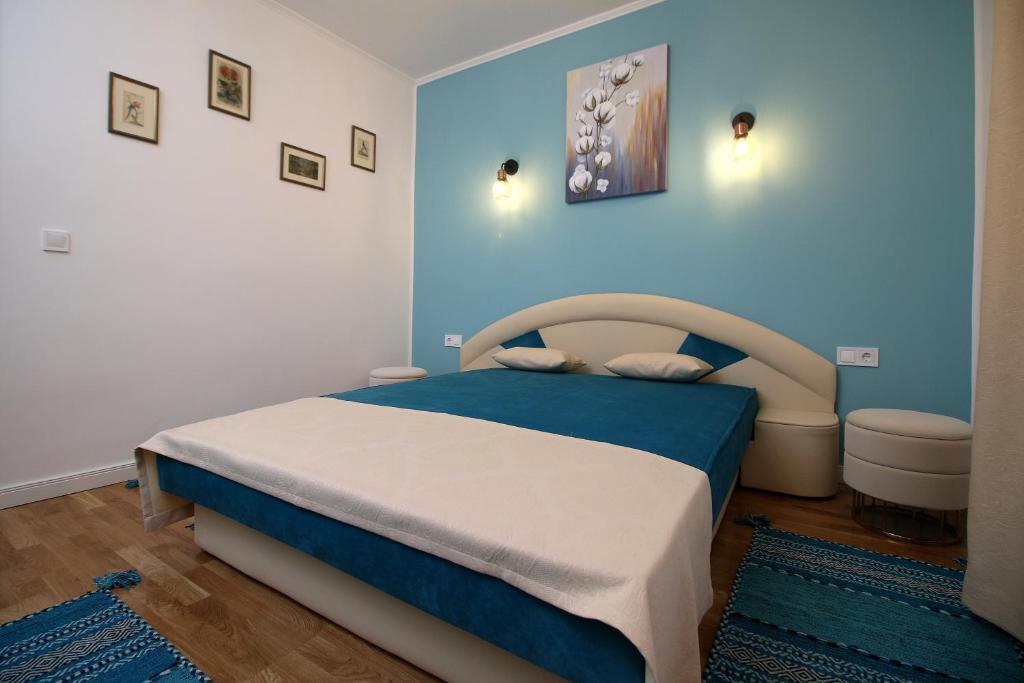 锡比乌White Stone的一间卧室设有一张床和蓝色的墙壁