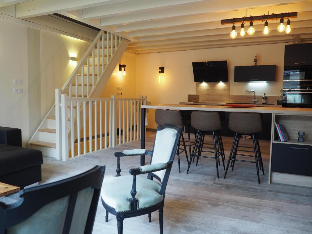 Martres-de-VeyreLa Meïzou de Bouly的客厅设有酒吧、椅子和楼梯