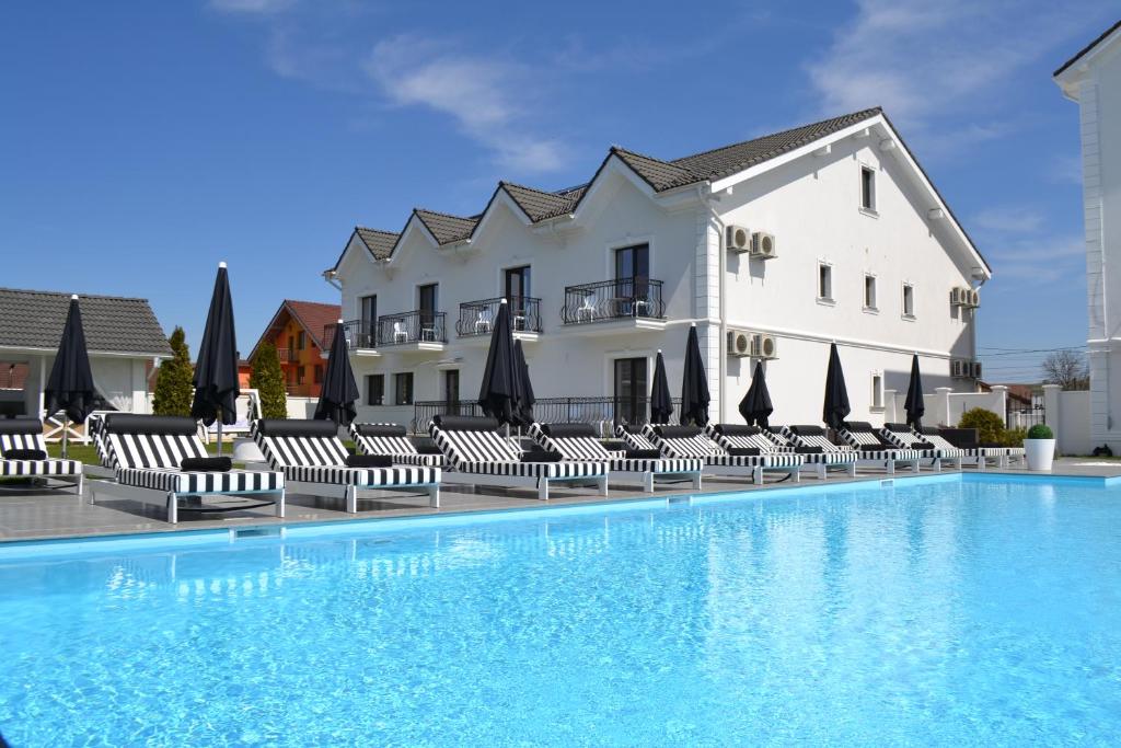 胡内多阿拉Krystal Boutique Mansion的酒店设有带椅子和遮阳伞的游泳池