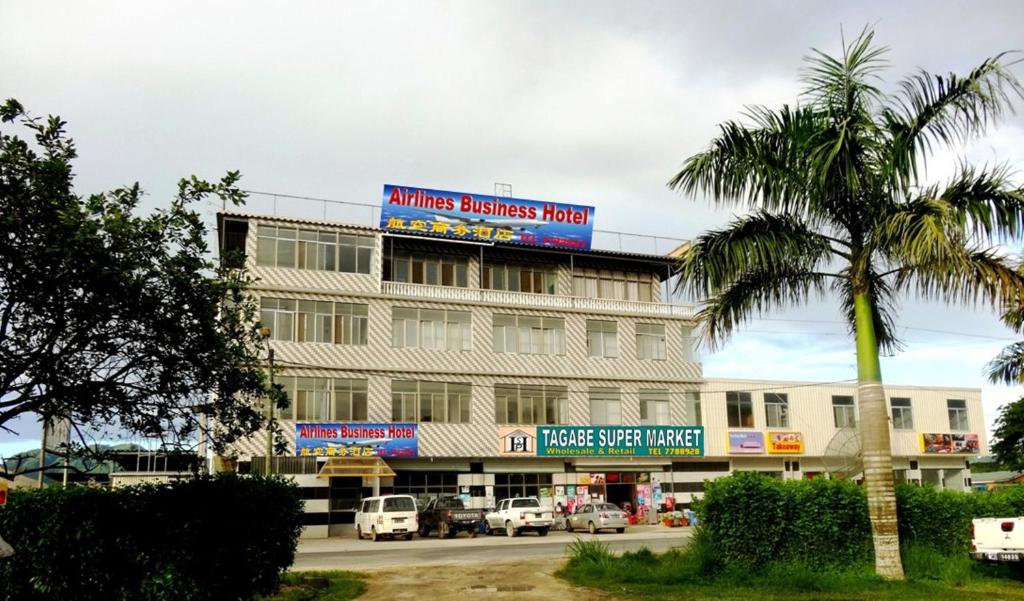 维拉港航空商务酒店 的前面有棕榈树的建筑