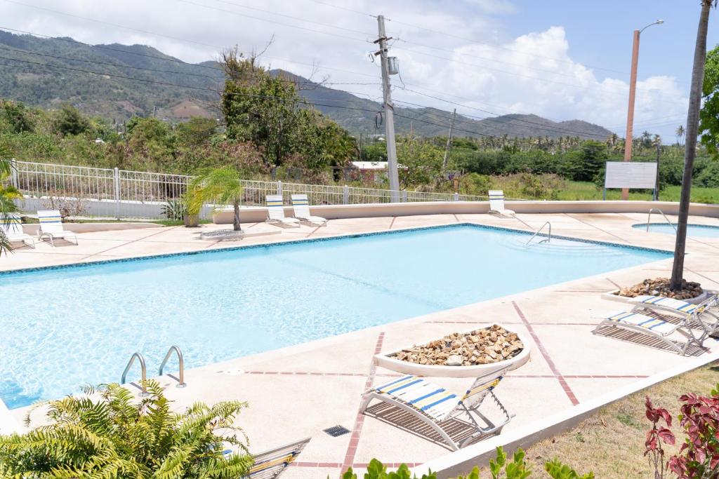 毛纳沃Apartment in Villas Del Faro Resort with WIFI的一座大型游泳池周围摆放着一束椅子