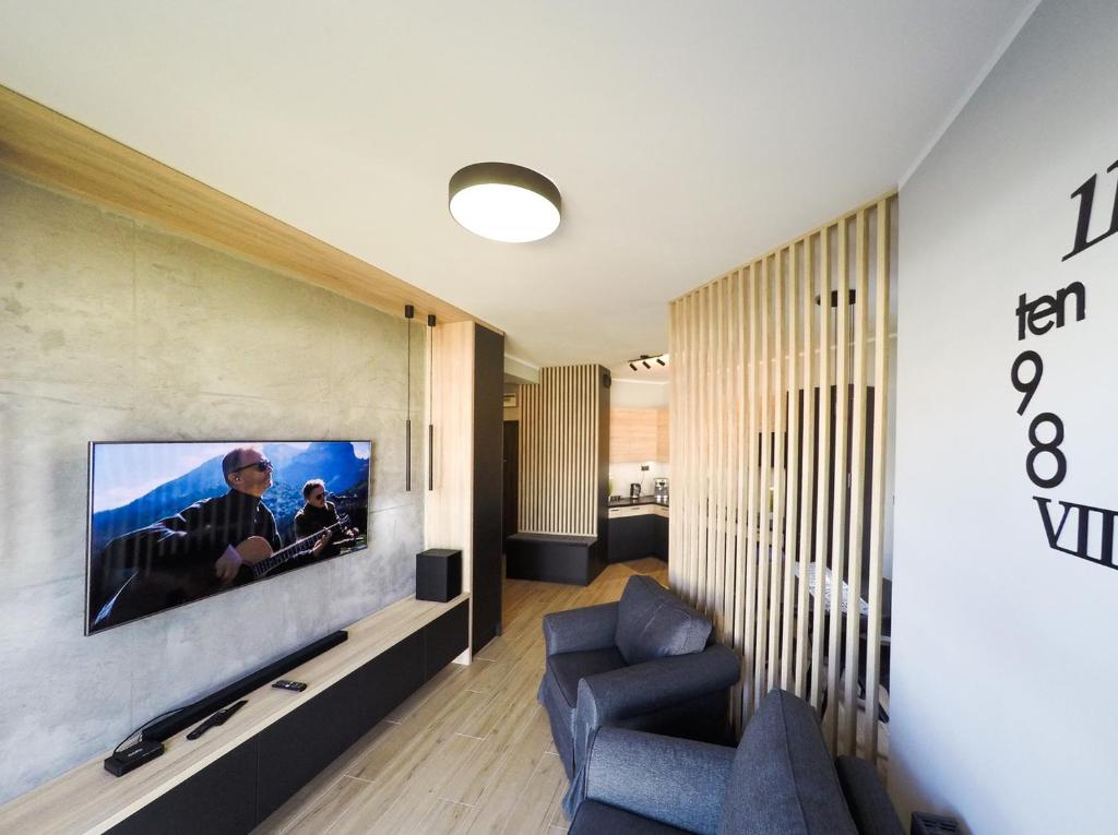 波兹南Apartament Malta Poznań的客厅的墙上配有电视