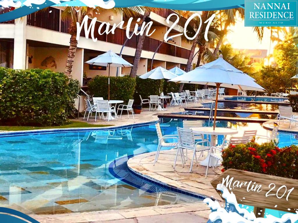 嘎林海斯港NANNAI RESIDENCE VISTA MAR Muro alto的一个带桌椅和遮阳伞的游泳池