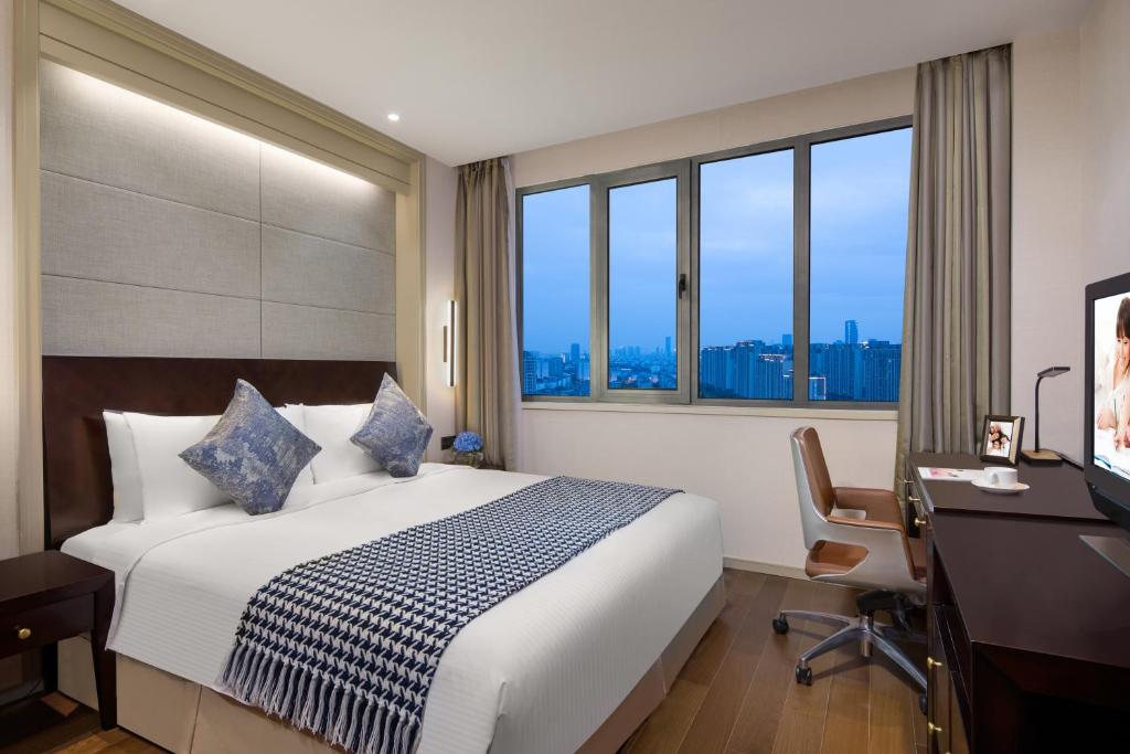 苏州苏州盛捷绿宝广场服务公寓的酒店客房设有一张床、一张书桌和窗户。