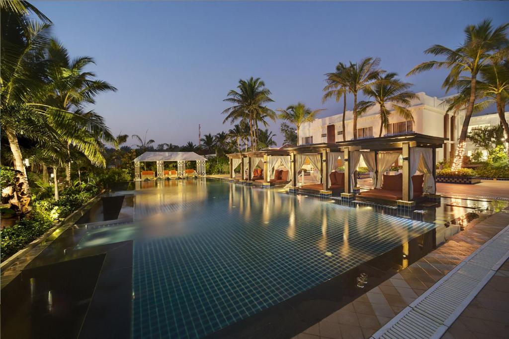 戈巴尔布尔Mayfair Palm Beach Resort的棕榈树屋前的游泳池