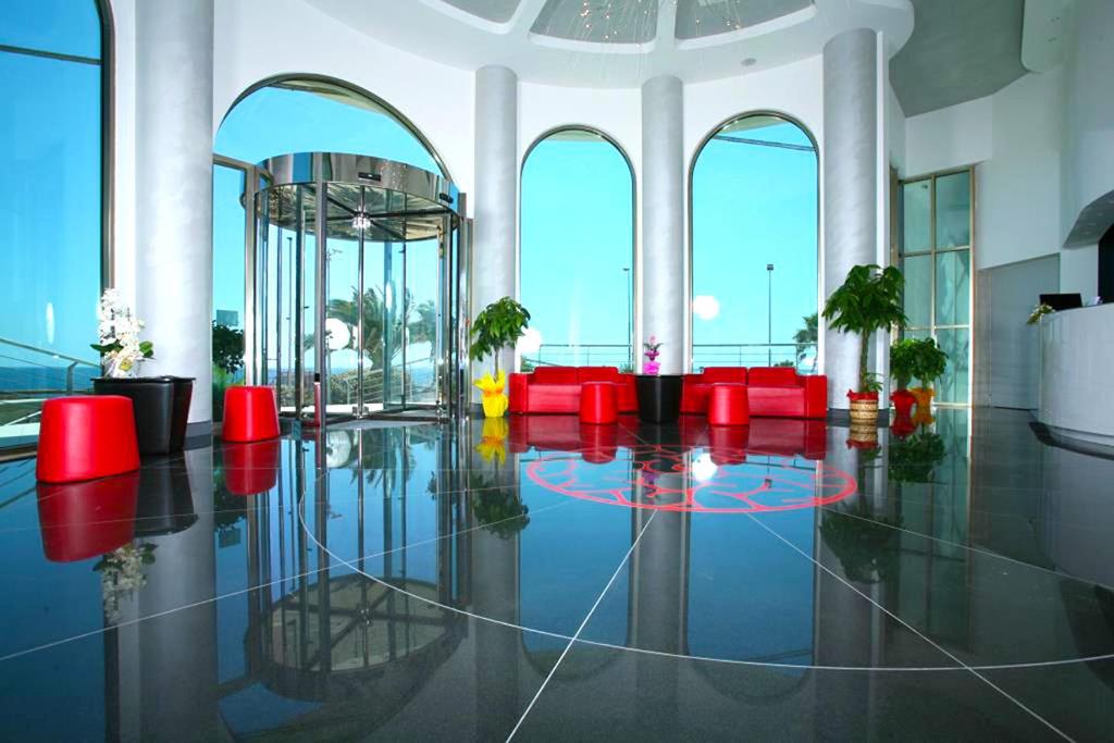 托雷圣乔万尼乌乔尼科酒店的大堂设有红色椅子,大房间设有窗户