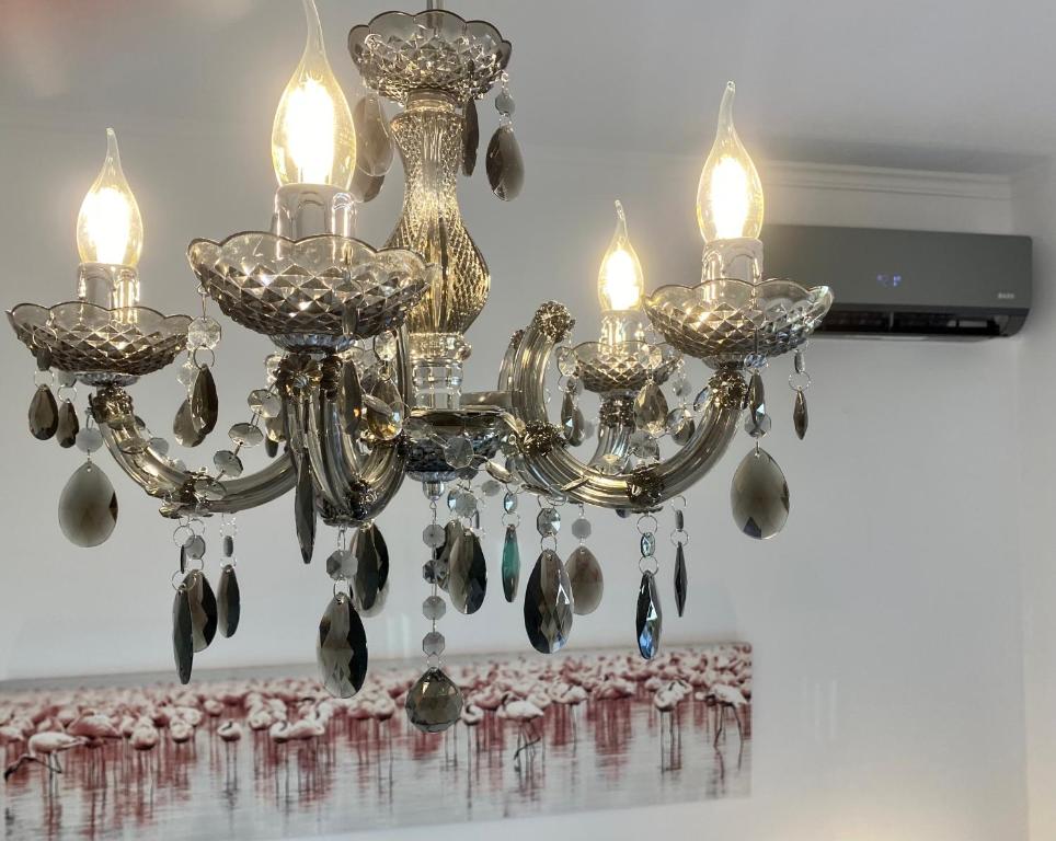 纳克索乔拉PORTA HOME modern and hospitable的一张吊灯,桌子上放着三个灯和羽毛