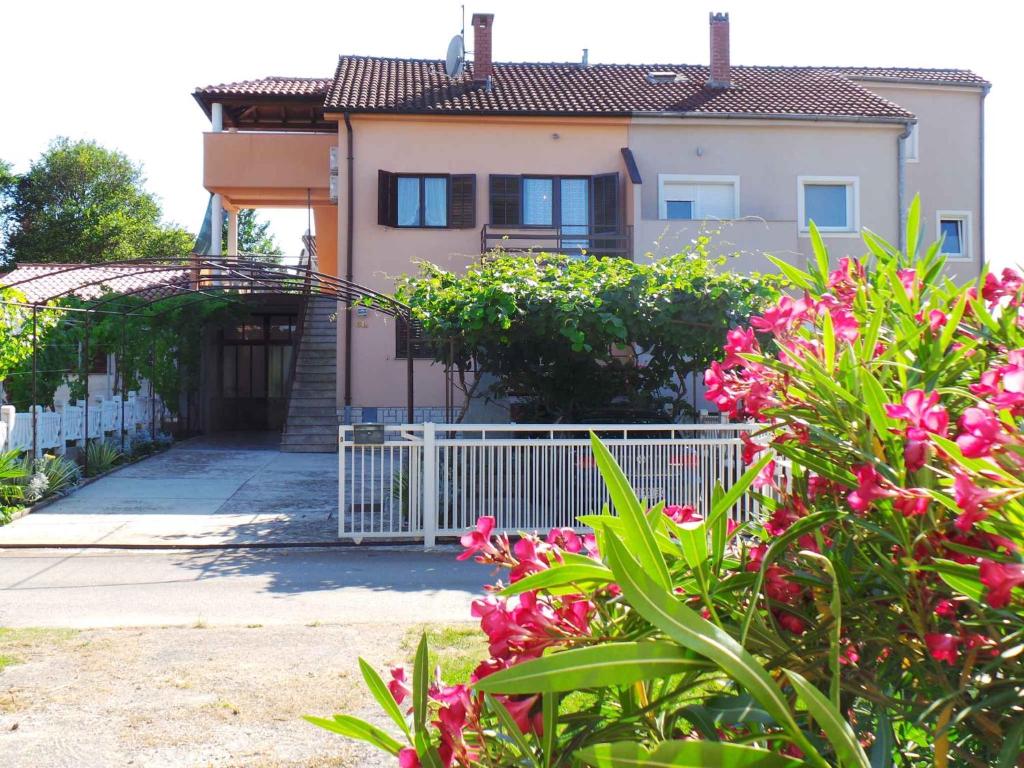 ValbandonApartment in Valbandon/Istrien 11260的白色围栏和粉红色花卉的房子