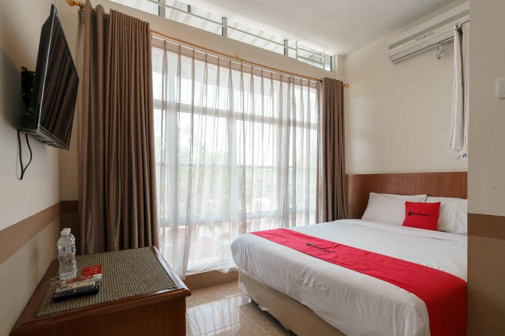 巴淡岛中心RedDoorz near Plaza Botania 1 Batam的一间卧室设有一张床和一个大窗户
