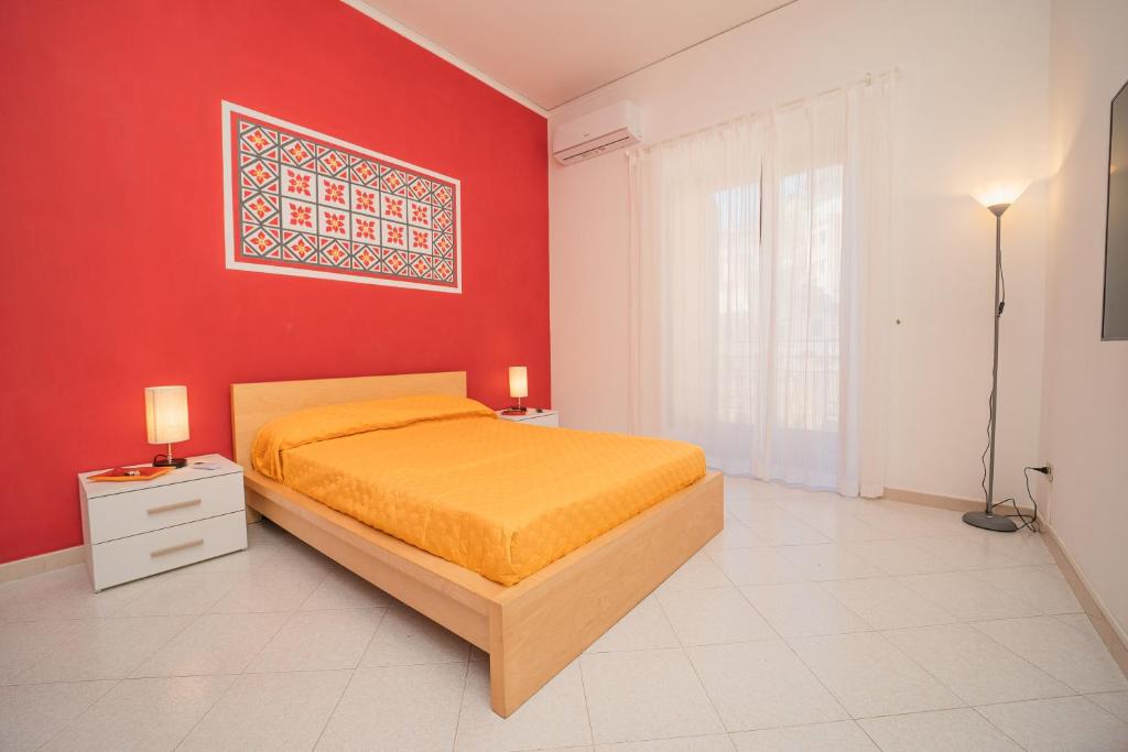 阿特拉尼Ada's House的一间卧室设有一张床和红色的墙壁