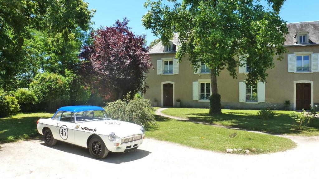 Vouneuil-sur-VienneLePireau fr Gîte Maître Futuroscope Piscine chauffée的停在房子前面的白色汽车