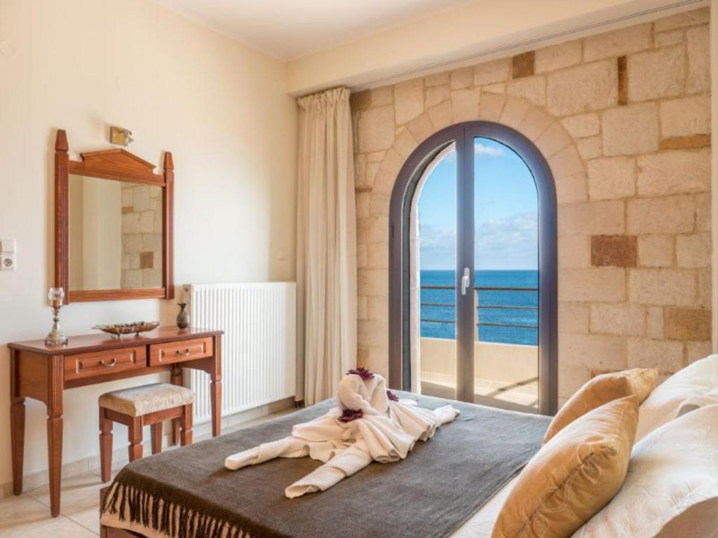 科林瓦里奥Xristinas Seaside Apartments的一间卧室设有一张床,享有海景