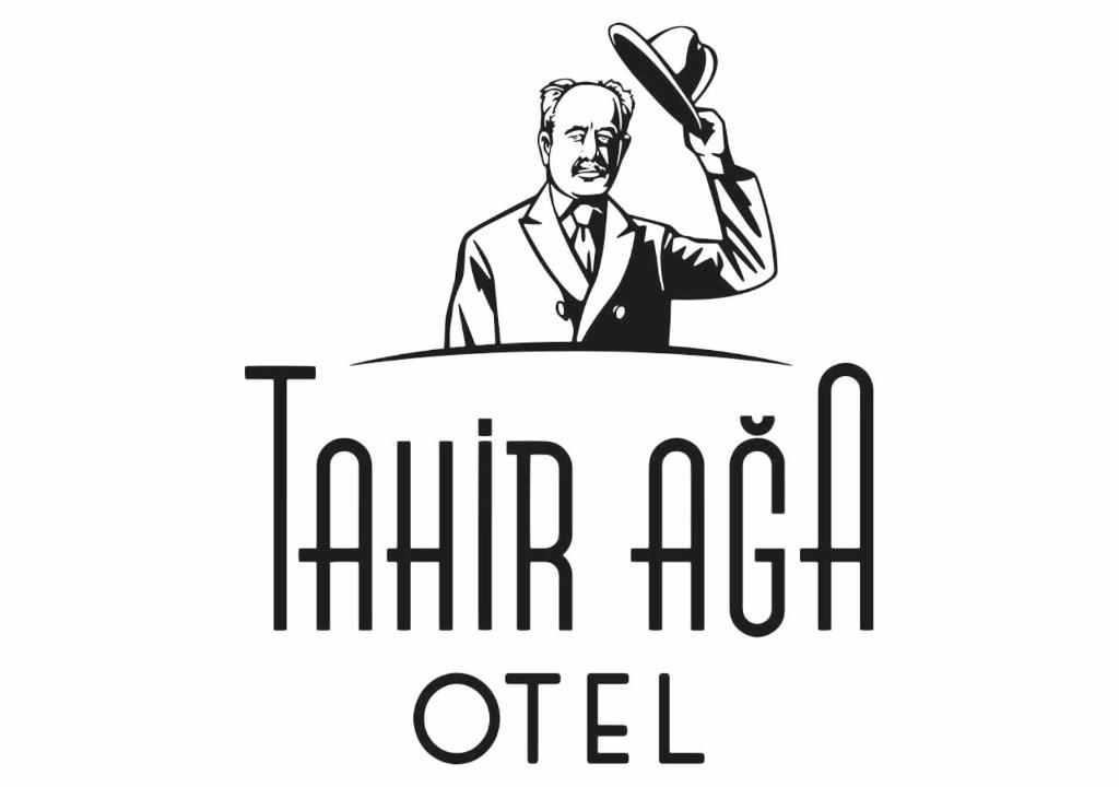 达特恰Tahirağa Otel的穿着西服的人手里拿着勺子站在桌子旁