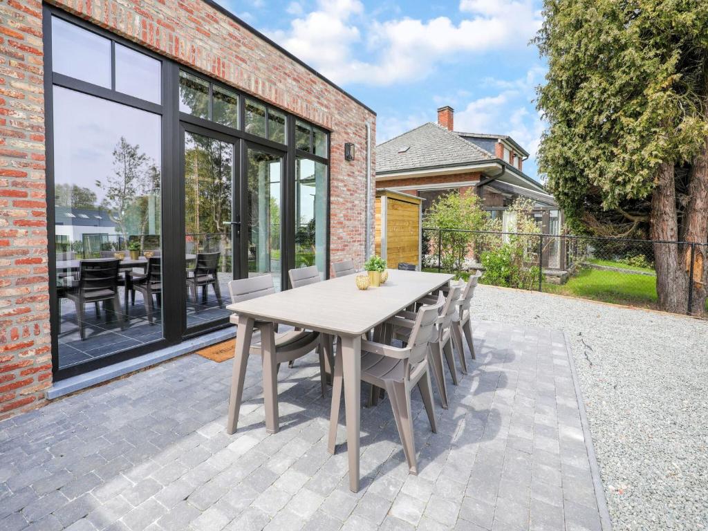 龙塞Beautiful house in Flemish Ardennes for cyclists的砖砌建筑中带桌椅的庭院