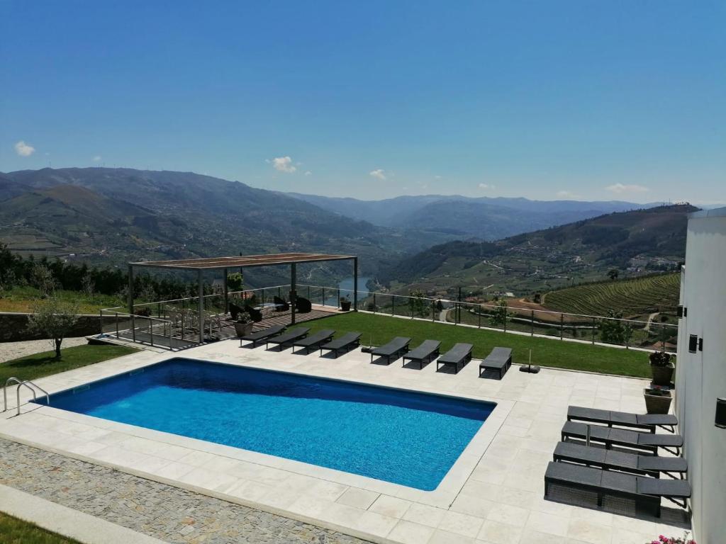 梅桑弗里乌Casa Miradouro的一个带椅子的游泳池,享有山景