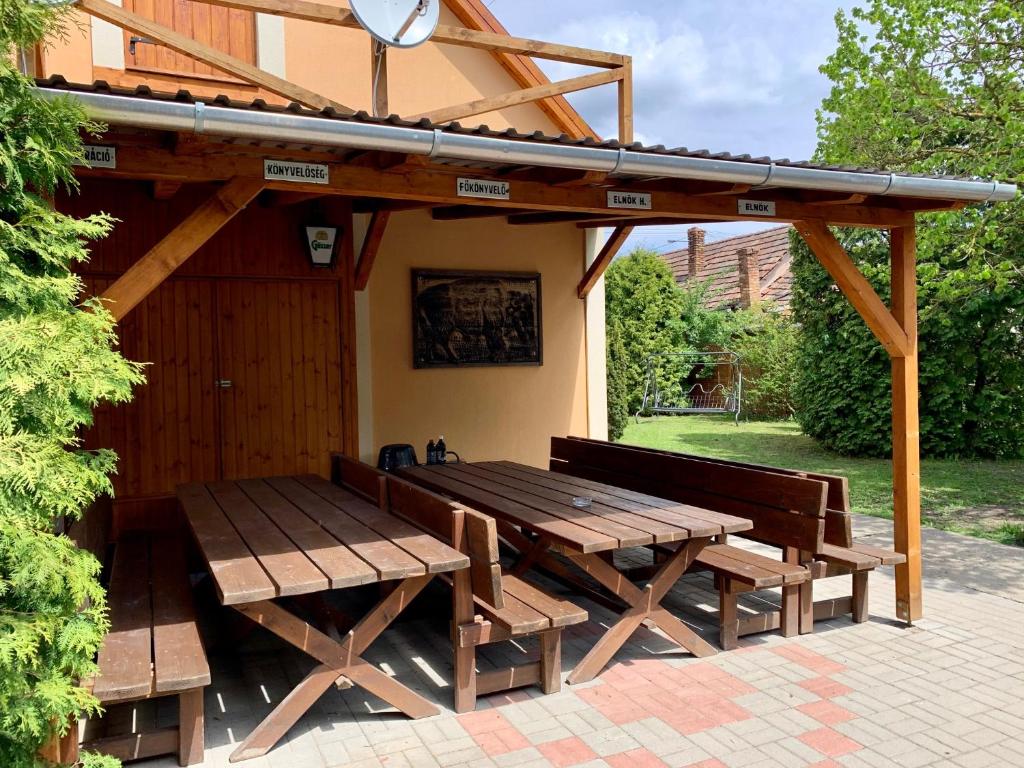 MátraterenyeMátrai Vadászház 2的凉亭下的木餐桌和长椅