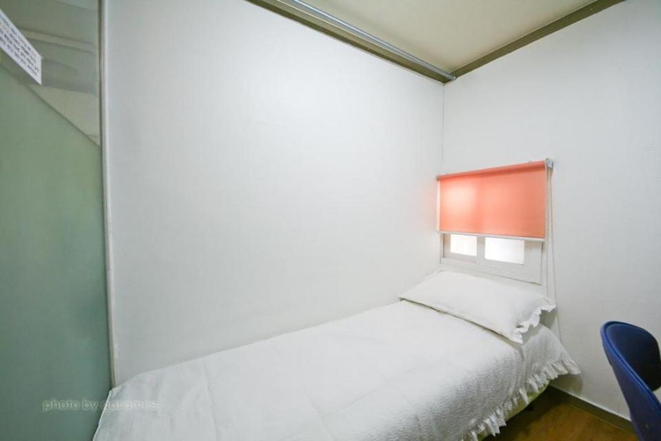 首尔Rodemhouse的卧室配有白色的床和窗户。