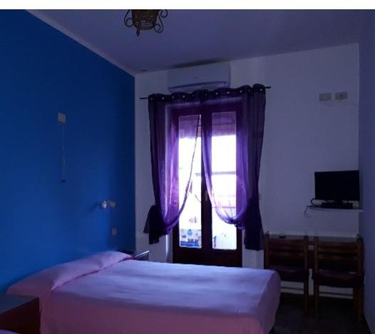 弗卡诺Hotel Torre的蓝色的卧室设有床和窗户