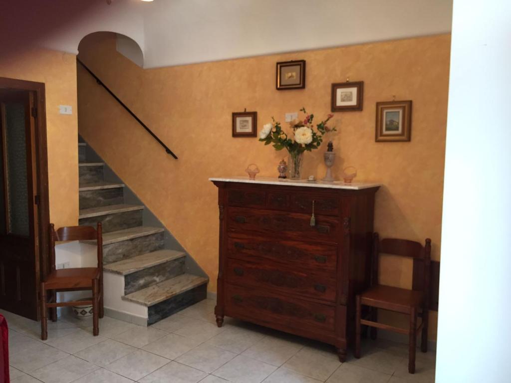 Caltabellottacasa MARINO的一间设有楼梯的房间和一个带花瓶的梳妆台